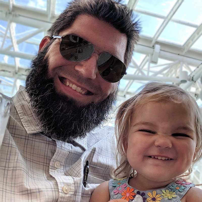 Photo of Nick Linn, man with sunglasses and beard, along with two year old daughter, both smiling.